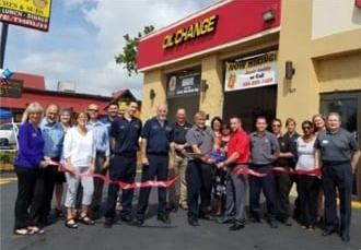 A crowd of smiling Take5 members at a ribbon cutting in 2016